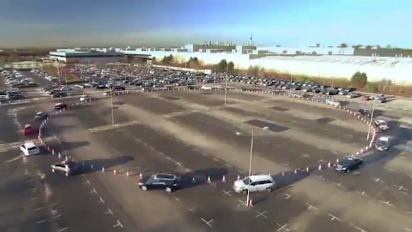 An aerial view of a busy roundabout demonstrates how information waves propagate backward through traffic, analogous to pressure waves in fluid flow — until speeds become too high for proper reaction.