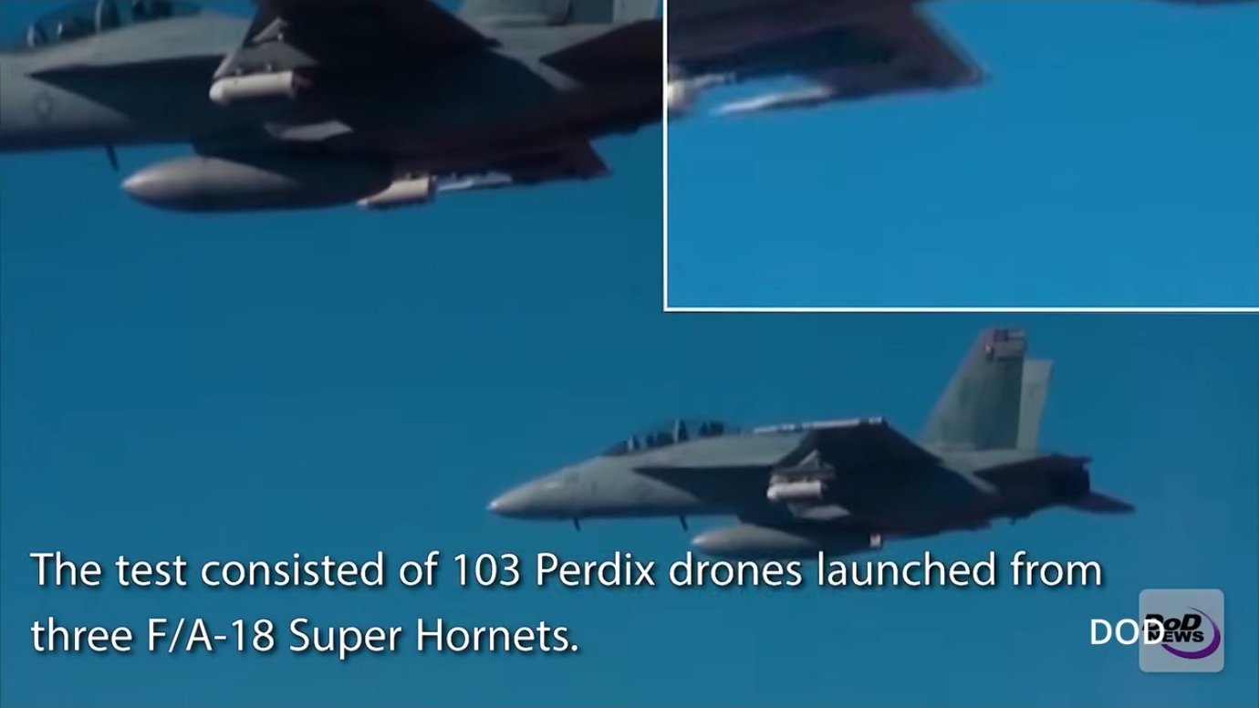 Aerial view of a large-scale test involving 103 Perdix drones launched from three F/A-18 Super Hornets. The scale demonstrated here—over a hundred coordinated platforms—shows why autonomous swarm technology matters: no human team could individually pilot this many aircraft simultaneously.