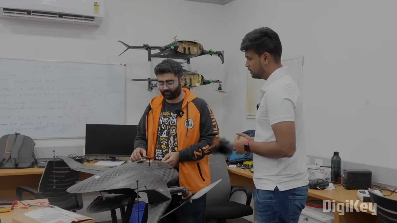 Development workspace with multiple VTOL drones wall-mounted for reference. Engineers test firmware updates and control algorithms in simulation before deploying to physical aircraft, reducing the risk of costly flight failures.