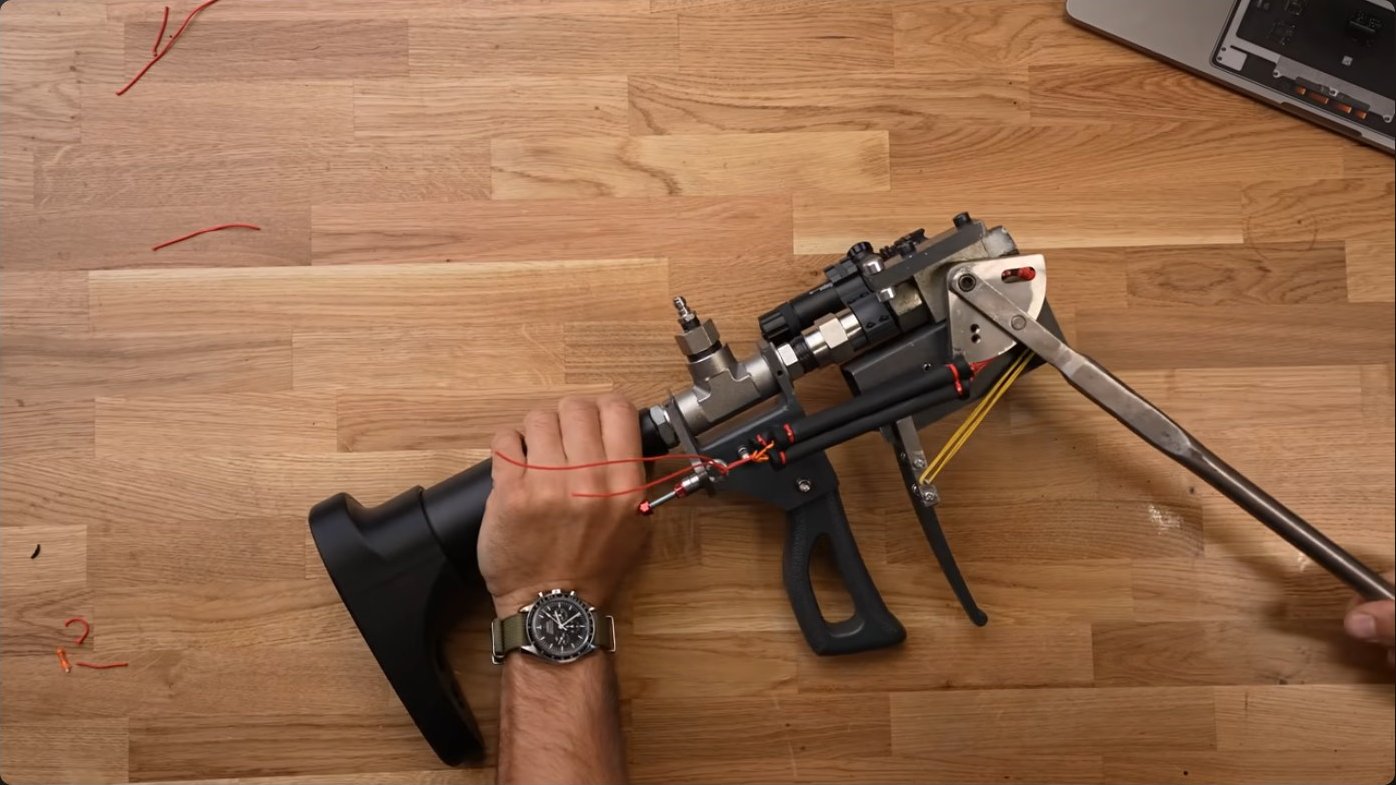 Overhead view of the fully assembled trigger mechanism mounted to the ball valve, showing how the elastic bands wrap around the custom lever and attach to the trigger assembly behind the grip.