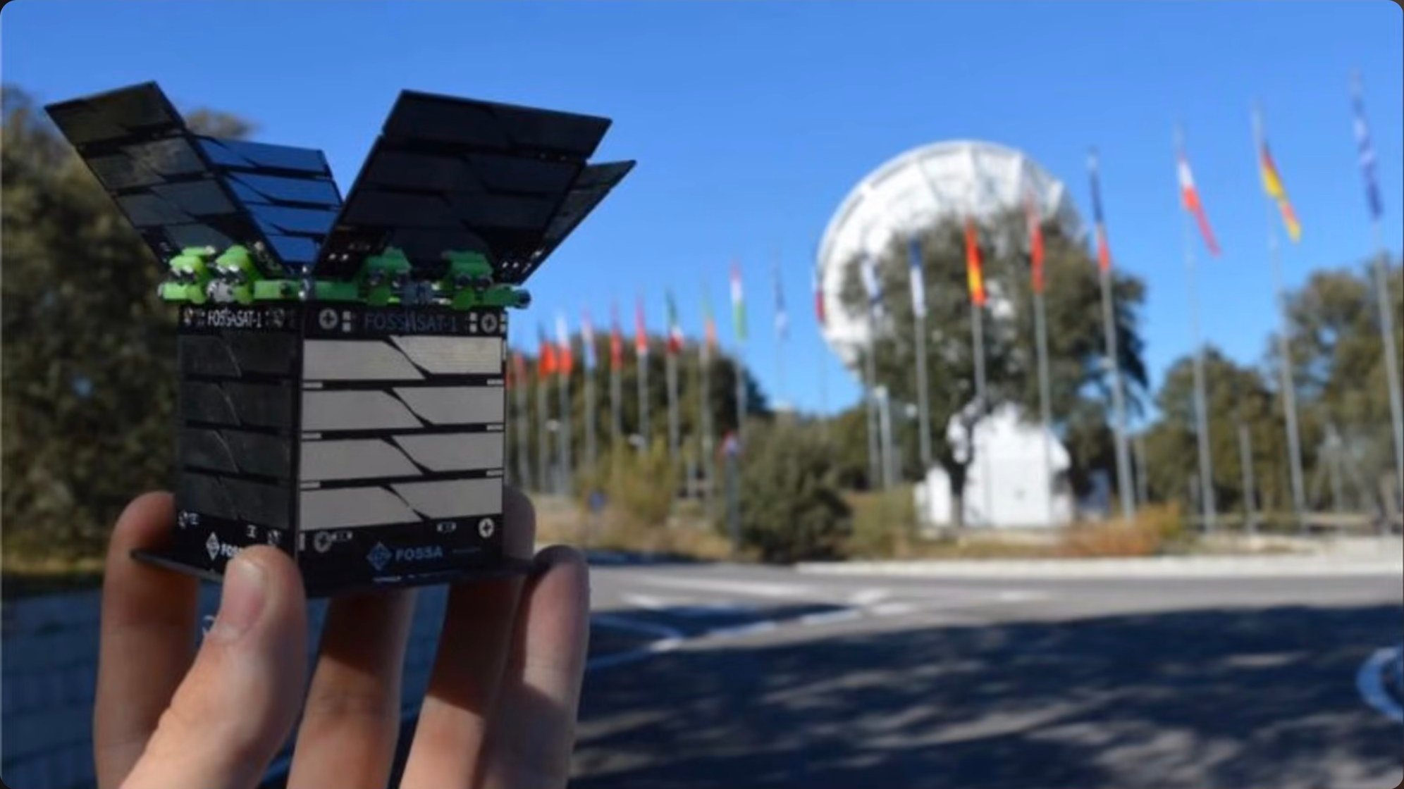 Field testing of a mesh node showing the device interfaced with a smartphone while positioned outdoors with a solar panel, demonstrating portable off-grid operation with renewable power supplementing battery capacity.