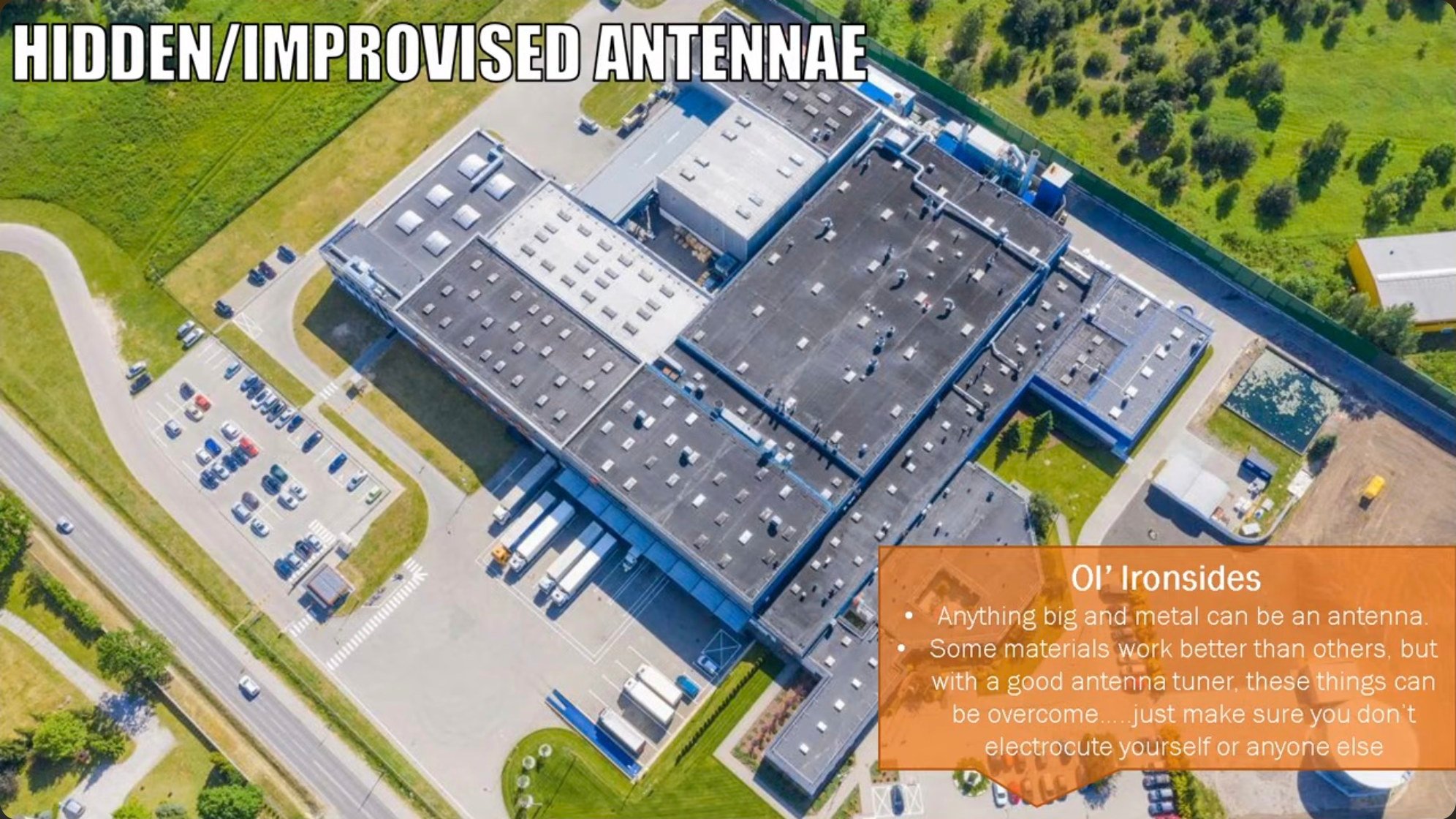 An aerial view of a warehouse complex where metal roofing could serve as an improvised antenna element, pre-existing in the environment and requiring no new installation that surveillance systems might detect.